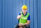Cheerful engineer man sitting and smiling on container box with giving thumbs up as sign of Success