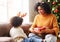 Cheerful ethnic family: happy child and mother congratulate each other at Christmas