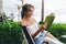 Cheerful ethnic lady reading book veranda of tropical hotel