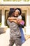 Cheerful excited african american wife embracing military husband after returning home from army