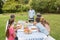 Cheerful extended family watching father at the barbecue