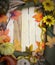 Cheerful fall or autumn border with fall leaves, nuts, sunflowers and squashes with green folded burlap and gold ribbon on a woode