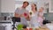 Cheerful family with baby cooking dinner. Portrait of joyful Caucasian family of bloggers preparing meal in kitchen at