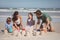 Cheerful family making sand castle at beach