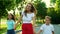 Cheerful family meeting father on street. Smiling woman hugging man outside