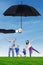 Cheerful family playing under umbrella at field