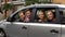 Cheerful family sitting in car and smiling into camera, auto rental, insurance