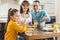 cheerful family sitting at table with pancakes father pointing on juice by hand