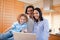 Cheerful family surfing the internet in the kitchen together