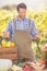 Cheerful farmer holding red and green peppers