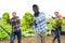 Cheerful farmers dancing with harvested lettuce in hands in field