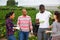 Cheerful farmers discussing during break on field