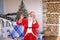 Cheerful Father Christmas congratulating on holiday by smartphon