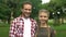 Cheerful father and teenage daughter smiling into camera, showing thumbs up