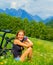 Cheerful female with bicycle on green field