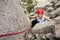 Cheerful female climber ascending a rock