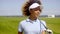 Cheerful female golfer walking with golf club