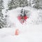 Cheerful female having fun in the snow, throwing it up above