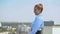 Cheerful female manager enjoying cityscape standing office terrace, work break