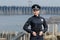 Cheerful female ukrainian police officer standing against urban background