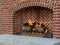 Cheerful fire burns in brick fireplace heating outdoor space