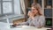 Cheerful freelancer woman smiling drinking tea chatting surfing internet on laptop sitting at desk