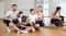 Cheerful friendly sporty parents with teen children posing in yoga class