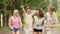 Cheerful friends dancing and waving hands at concert in park, summer weekend