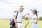 Cheerful friends giving high-five at golf course