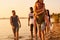 Cheerful friends walking together over coastline