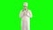 Cheerful funny mime in white robe imitating work of the doctor. One actor making show on green background. Chromakey