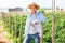 Cheerful gardener posing in farm backyard in summer