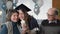 cheerful girl in academic hat and gown together with joyful parents celebrates graduation and graduation online