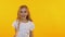 Cheerful girl dancing funny dance on isolated yellow background, slow-motion