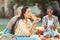 Cheerful girl drinking on her picnic with friends.