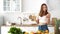 Cheerful girl eats a banana in a white kitchen