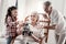 Cheerful girl and grandpa showing robot to grandma