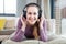 Cheerful girl with headphones lying down, enjoying listening to music