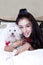 Cheerful girl and maltese dog in the bedroom