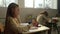 Cheerful girl sitting at desk in school. Focused student learning in classroom