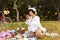 Cheerful girl sitting in hat and white shirt happily taking phot