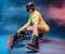 Cheerful girl with snowboard in yellow sportswear in studio