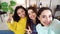 Cheerful girl taking selfie photo with multiracial roommates at home