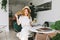 Cheerful girl in trendy vintage hat playing with blonde hair and laughing relaxing in cafe. Excited fair-haired lady in