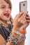 Cheerful girl using smartphone wrapped in metal chain