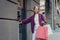 Cheerful girl in violet sweater going to the clothing store