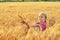 Cheerful girl on a walk near the field with wheat