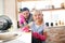 Cheerful girl wearing pink gloves helping daddy with housecleaning