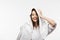 Cheerful girl wiping wet clean hair with white towel while looking at camera