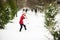 Cheerful girl of younger school age builds snowman.